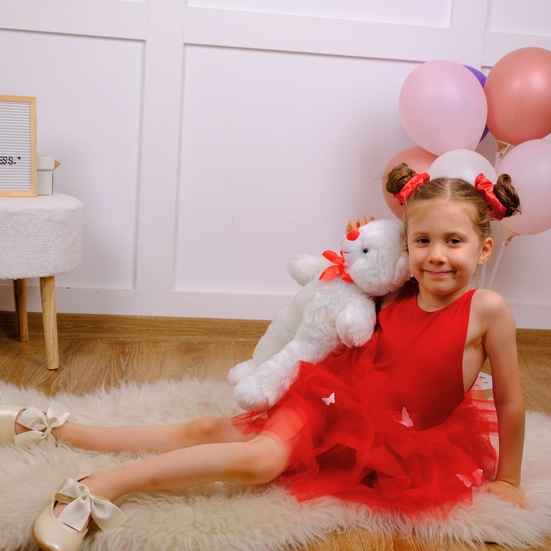 a little girl sitting on the floor with a teddy bear Baby Girl Dress for Special Occasion