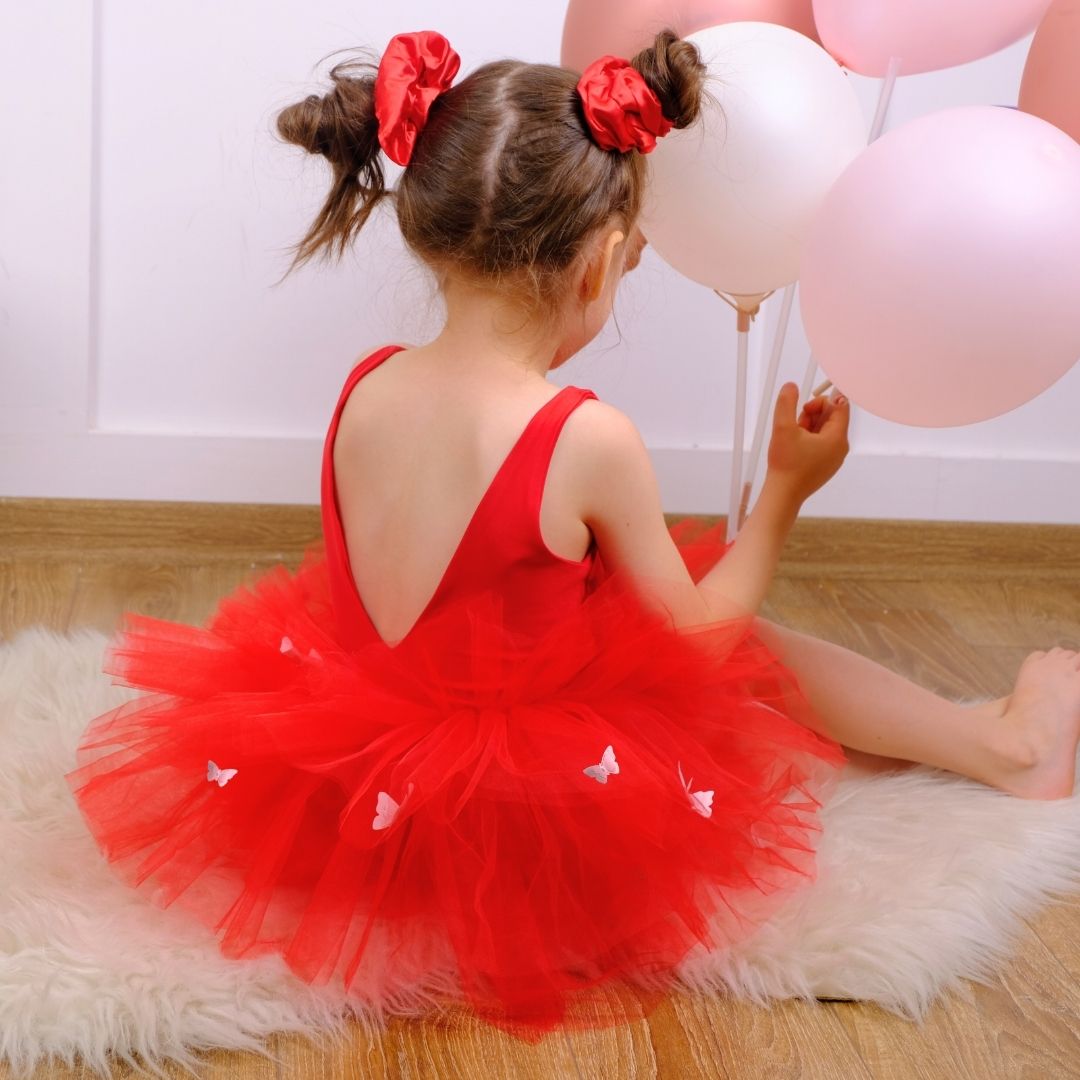 a little girl sitting on the floor with balloons Baby Girl Dress for Special Occasion