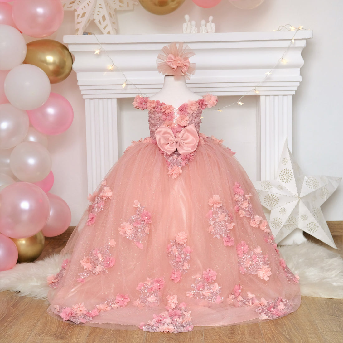 Blush pink Quinceañera gown featuring a satin bodice adorned with 3D colorful flowers and intricate lace details, with a soft cotton lining for comfort. The multi-layered tulle skirt includes glittery tulle, lace, and 3D flowers, complemented by a cotton lining. Comes with a matching gift hair accessory. Baby Girl Dress for Special Occasion