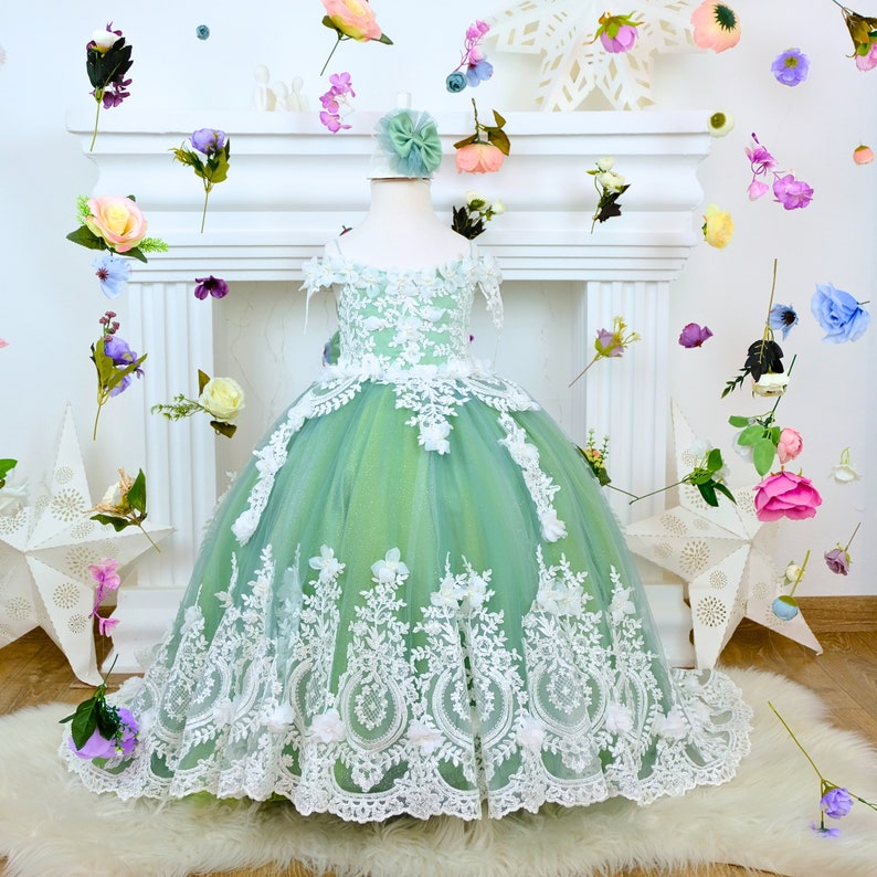 The corset part of the sage green dress is laced and has laser flowers on it. The whole skirt is embroidered with lace and tulle on tulle. Baby Girl Dress
