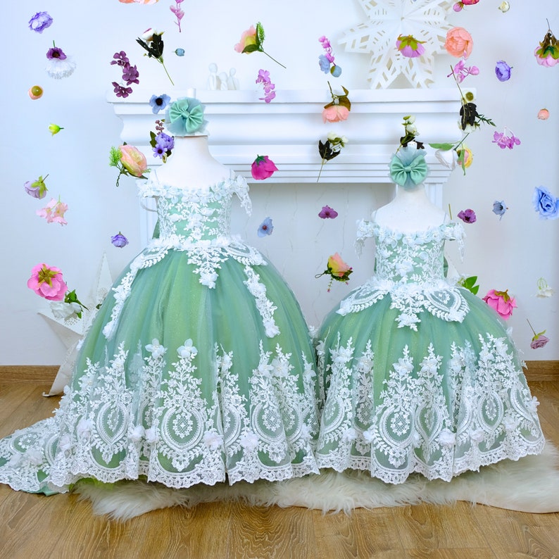 The corset part of the sage green dress is laced and has laser flowers on it. The whole skirt is embroidered with lace and tulle on tulle. Baby Girl Dress