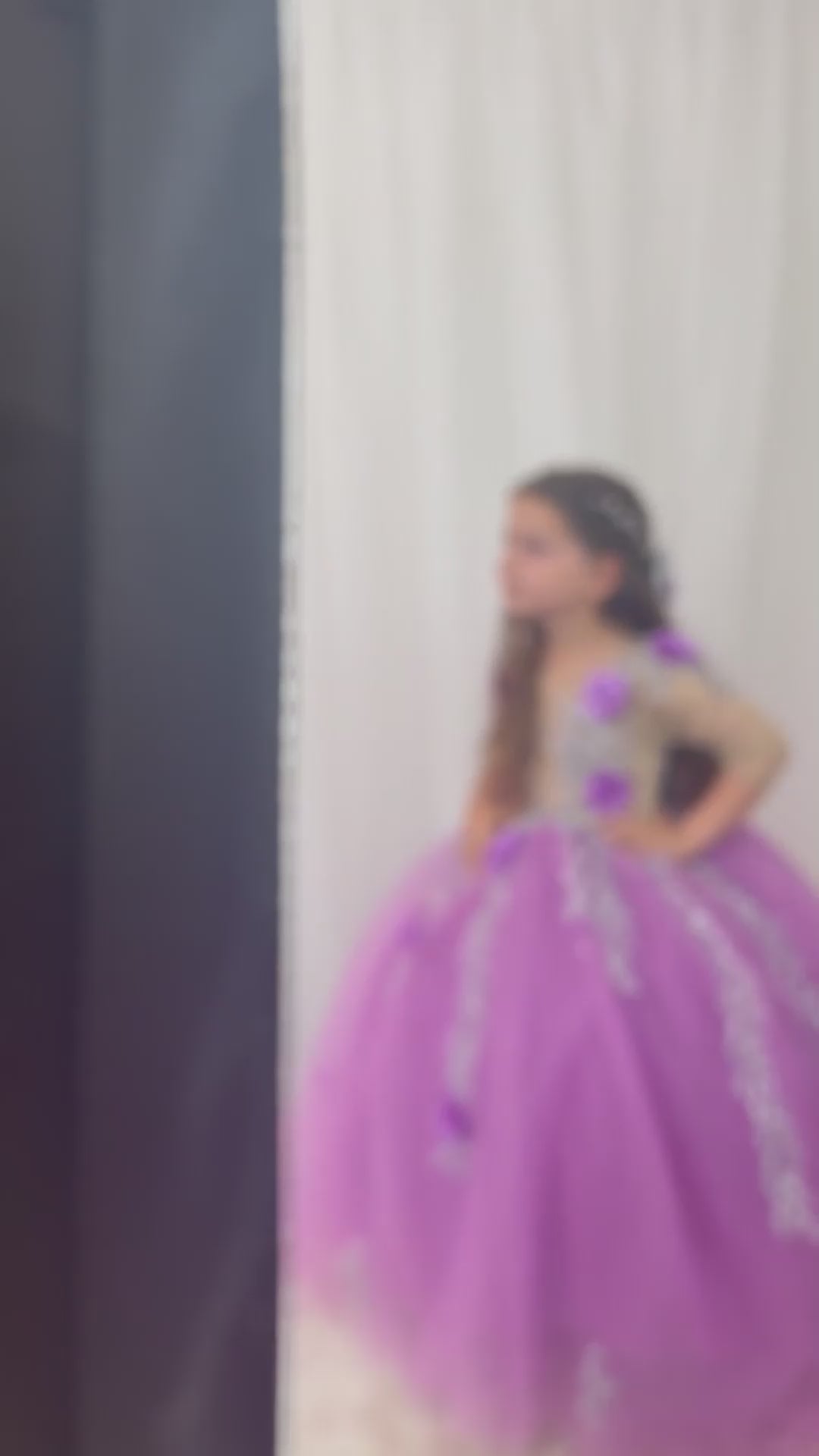 Charming lilac quinceañera dress with a satin bodice detailed with lace and colorful 3D flowers, a full tulle skirt adorned with glitter, and a matching hair accessory, designed for a stunning celebration. Baby Girl Dress