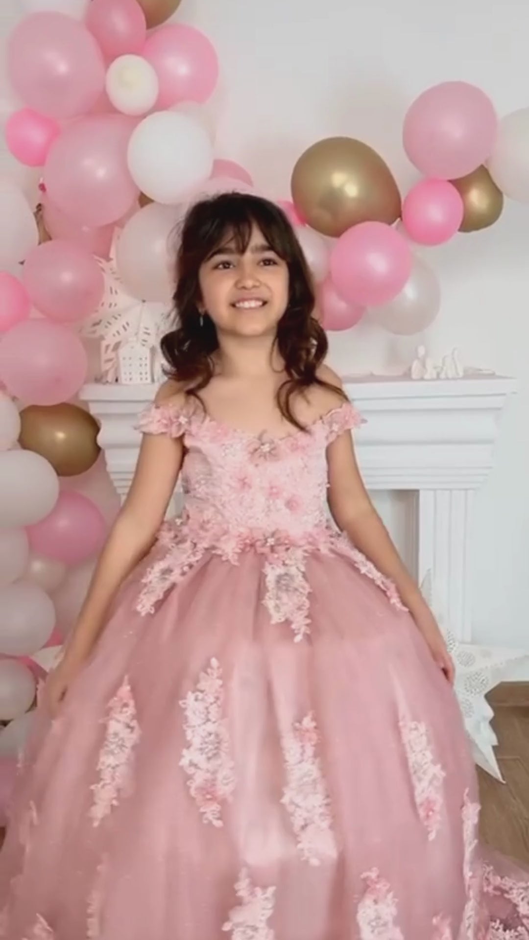 Elegant blush quinceañera dress featuring a satin bodice adorned with delicate lace and 3D floral appliqués, a voluminous tulle skirt with sparkling accents, and a coordinating hair accessory for a stunning look. Baby Girl Dress