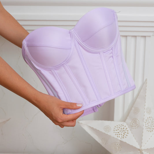 a woman is holding a purple corset in her hand Baby Girl Dress