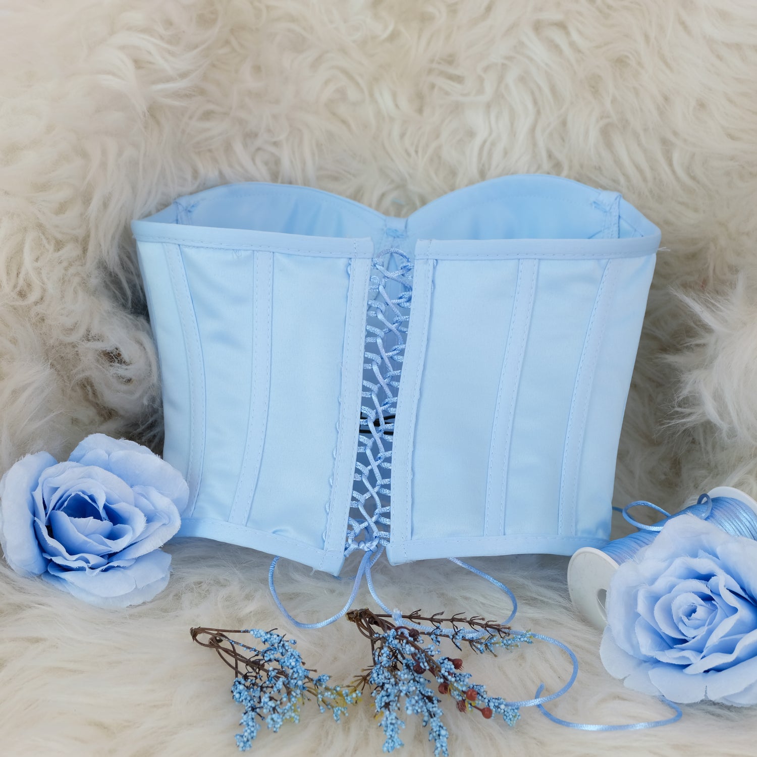 a blue corset with flowers on a furry surface Baby Girl Dress
