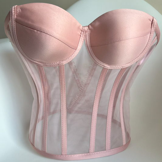 a pink corset sitting on top of a white chair