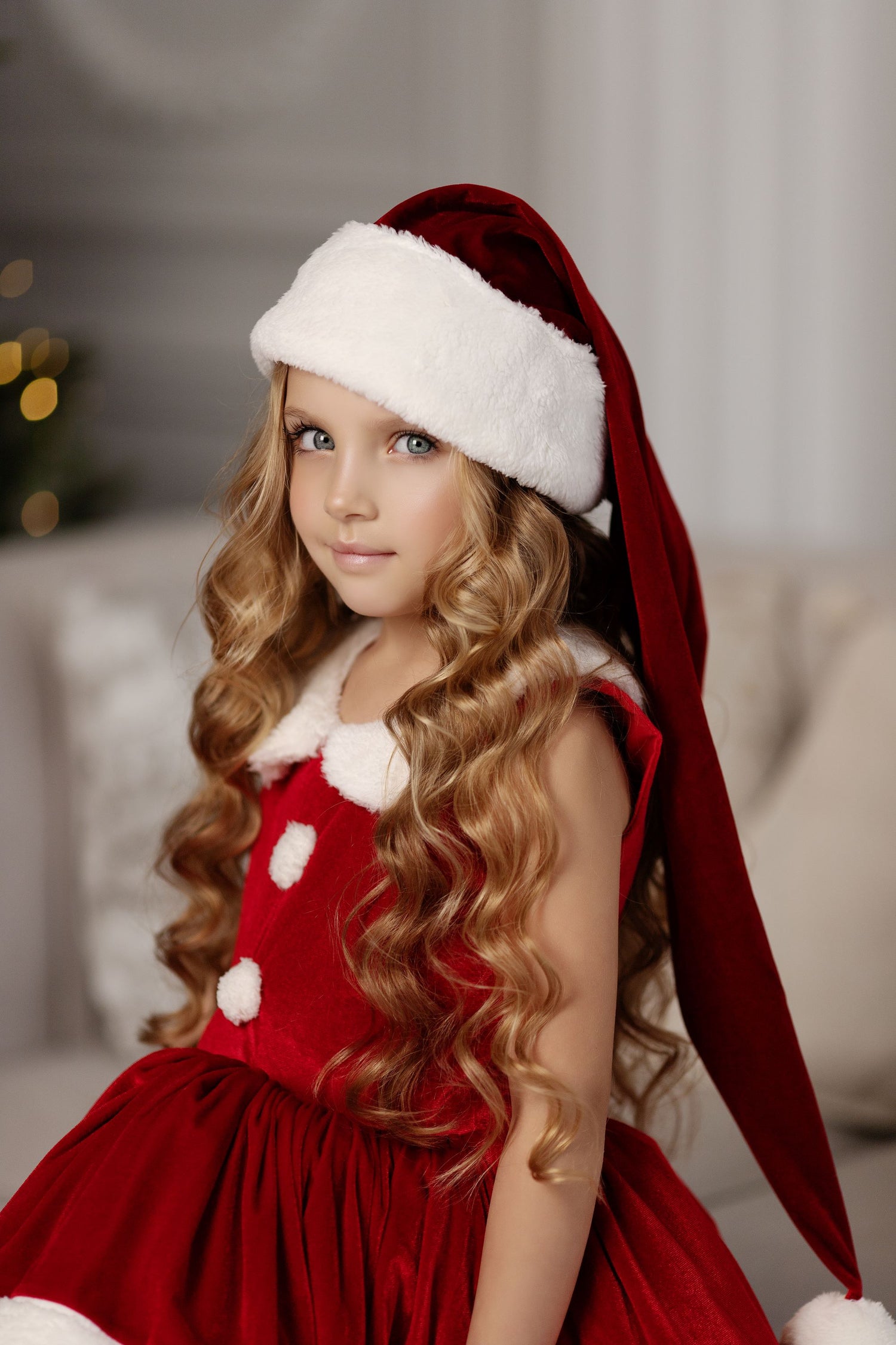 a little girl wearing a santa claus hat Baby Girl Dress