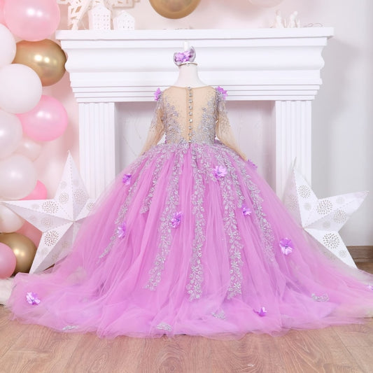 Lilac quinceañera dress featuring a satin bodice with intricate lace and 3D floral accents, a layered tulle skirt with sparkling glitter, and a matching hair accessory, perfect for a special celebration. Baby Girl Dress