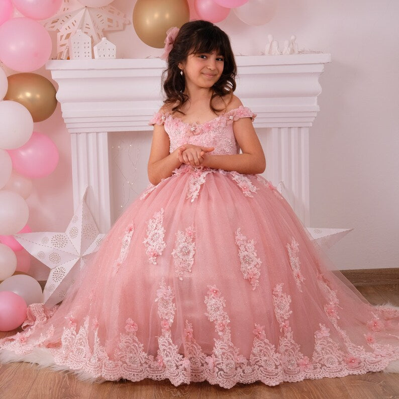 Beautiful blush quinceañera dress with a satin bodice embellished with lace and colorful 3D flowers, layered tulle skirt with glitter, and a matching hair accessory, perfect for a memorable celebration. Baby Girl Dress