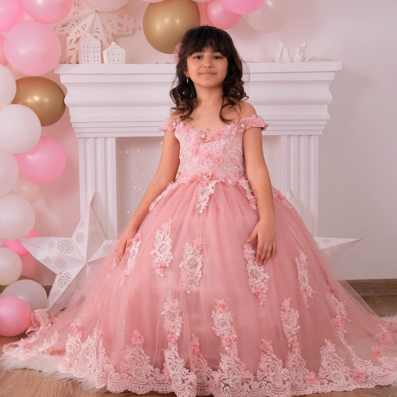Elegant blush quinceañera dress featuring a satin bodice adorned with delicate lace and 3D floral appliqués, a voluminous tulle skirt with sparkling accents, and a coordinating hair accessory for a stunning look. Baby Girl Dress for Special Occasion