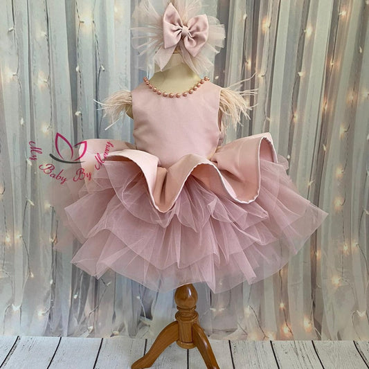 Adorable blush baby girl dress with delicate pearl detailing, featuring a soft and elegant design. Perfect for special occasions, this dress combines charm and comfort for your little one. Baby Girl Dress