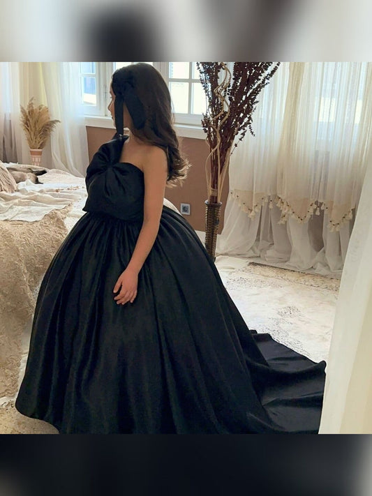a woman in a black dress standing in front of a window
