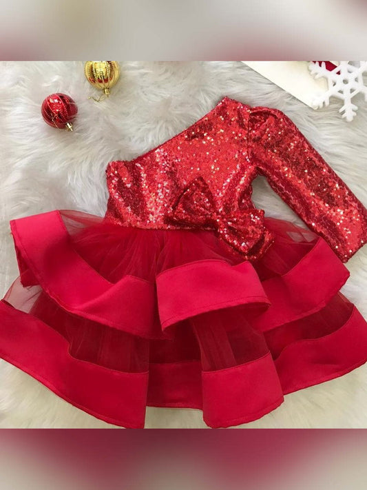 Front view of red Christmas girl dress with sequin design, one long shoulder, and puffy fluffy skirt for babies.