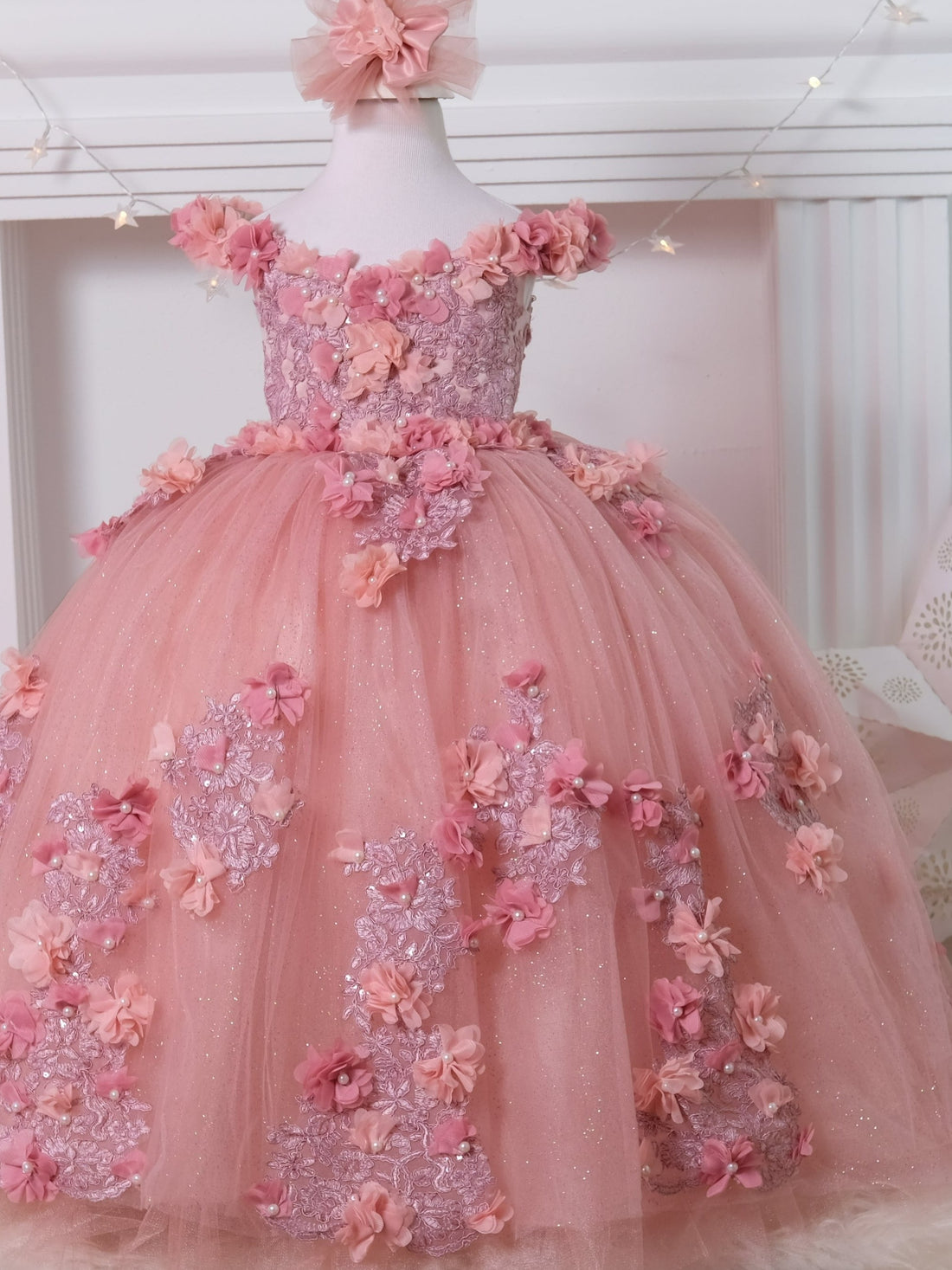 Delight in elegance with our satin and lace dress, featuring a bodice adorned with 3D colorful flowers and intricate details. The skirt boasts multiple layers of glittery tulle and lace, complemented by a soft cotton lining for comfort. Includes a matching gift hair accessory for the perfect finishing touch.