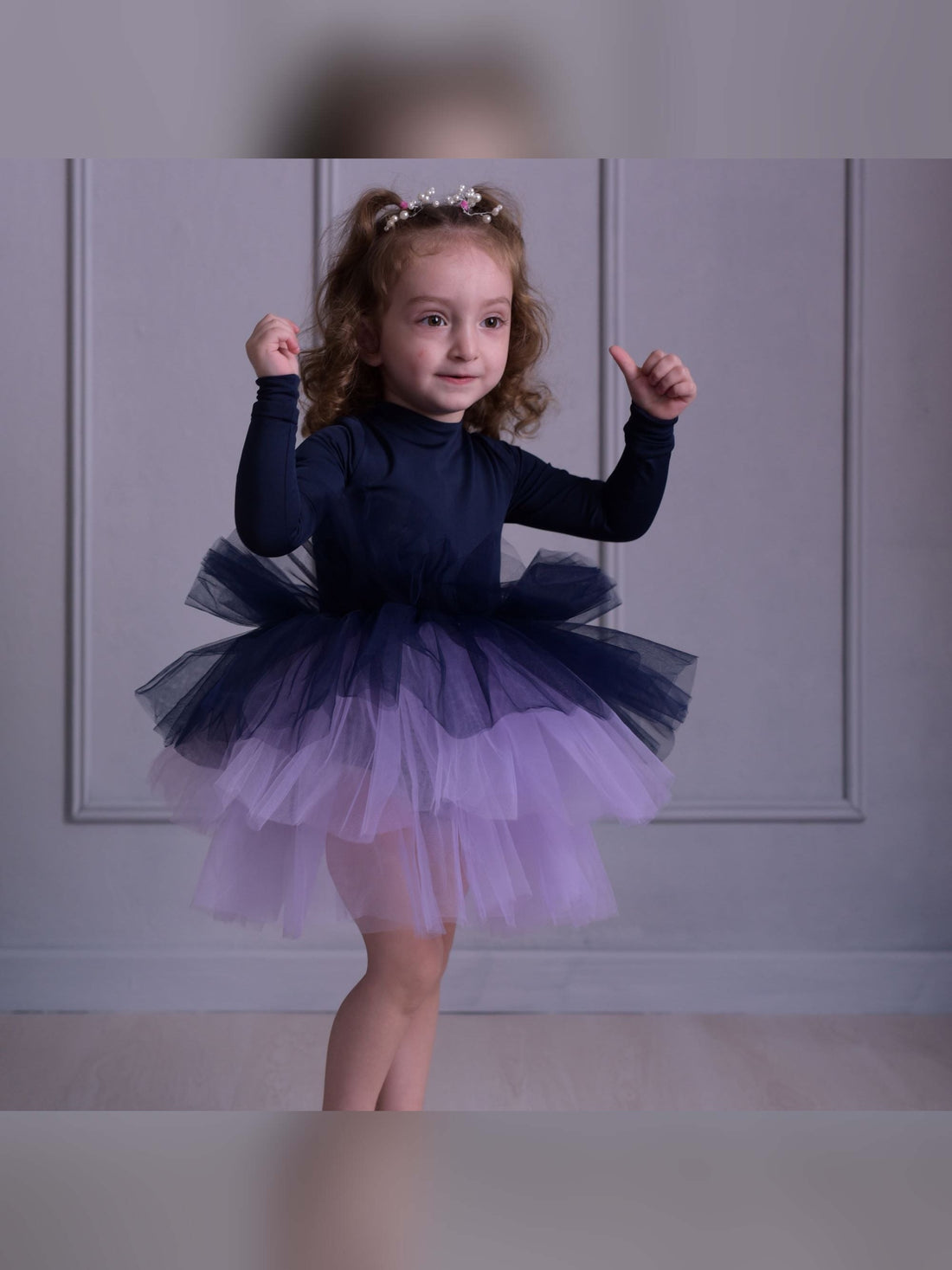 a little girl wearing a purple and blue dress