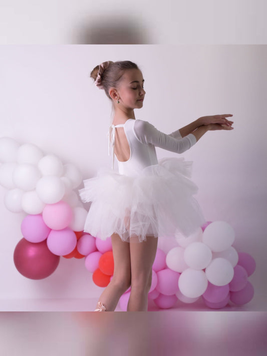 a young ballerina in a white tutu and ballet shoes