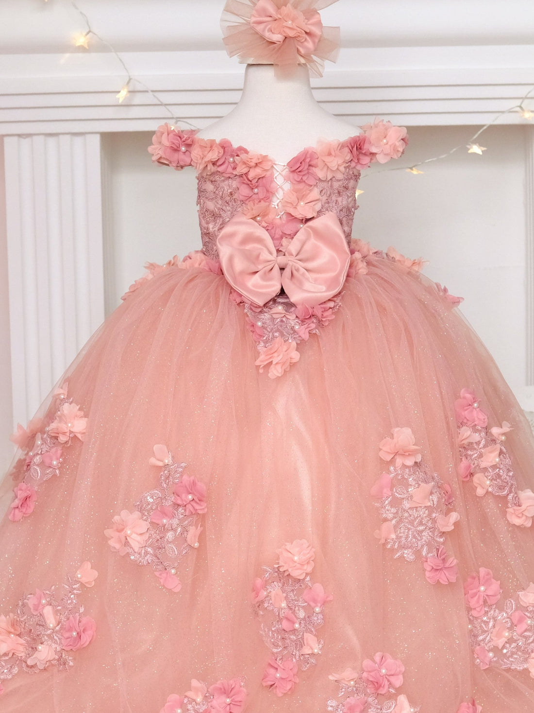 Delight in elegance with our satin and lace dress, featuring a bodice adorned with 3D colorful flowers and intricate details. The skirt boasts multiple layers of glittery tulle and lace, complemented by a soft cotton lining for comfort. Includes a matching gift hair accessory for the perfect finishing touch.