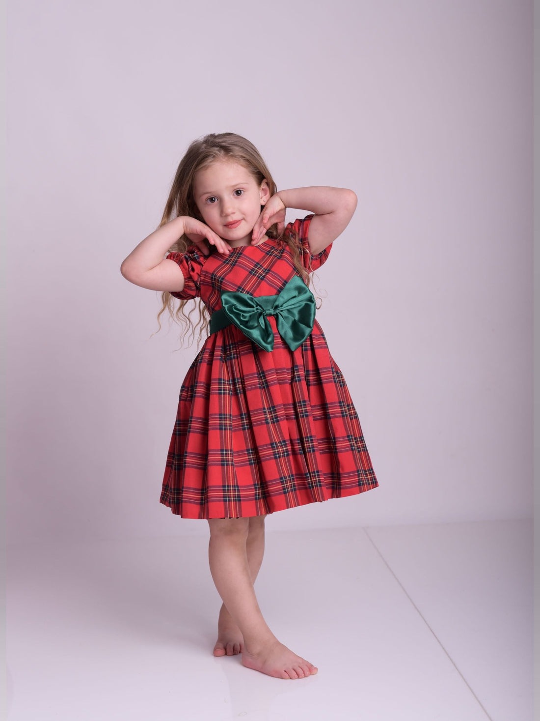 a little girl in a red dress posing for a picture