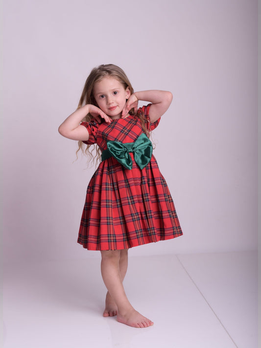 a little girl in a red dress posing for a picture