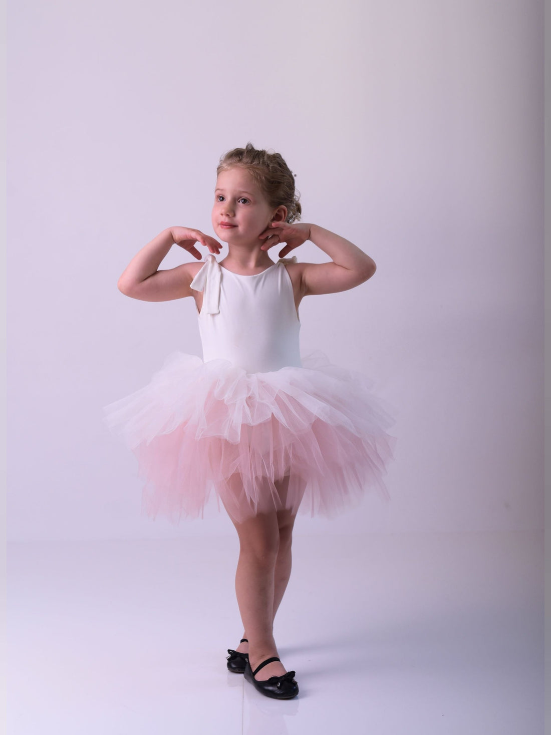 a little girl wearing a pink tutu and ballet shoes