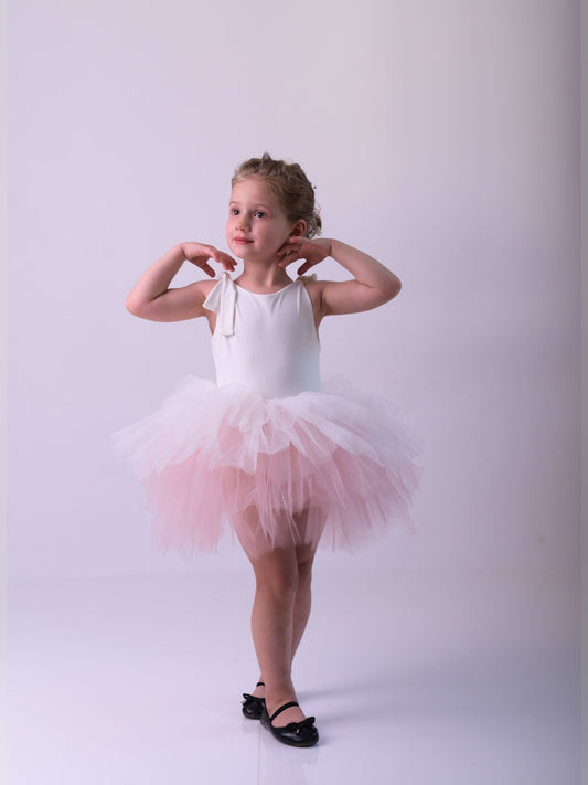 a little girl wearing a pink tutu and ballet shoes