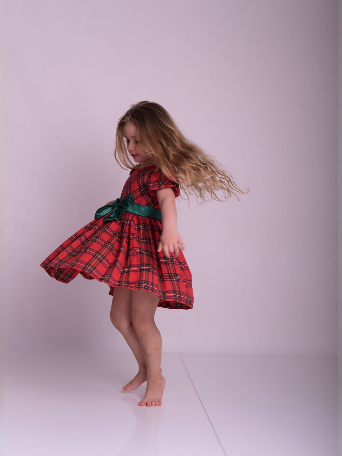 a little girl in a red and black dress