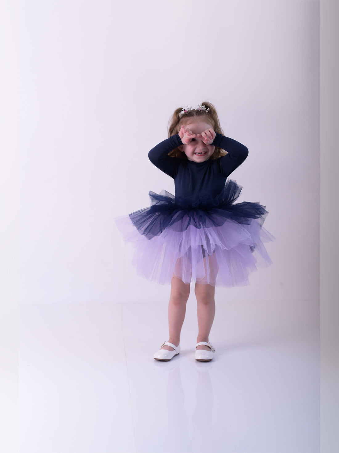 a little girl wearing a purple and blue dress