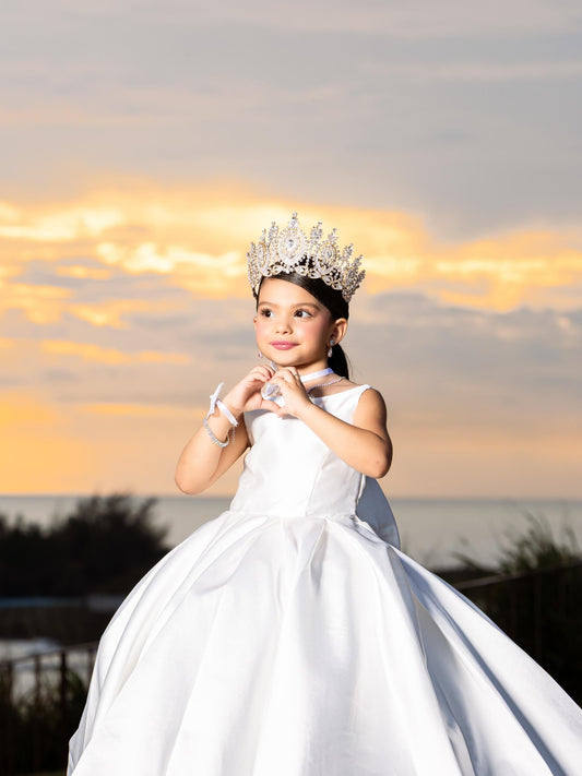 Girl wearing white satin flower girl dress outdoors
Size chart for girls satin ball gown sizes 2 to 14