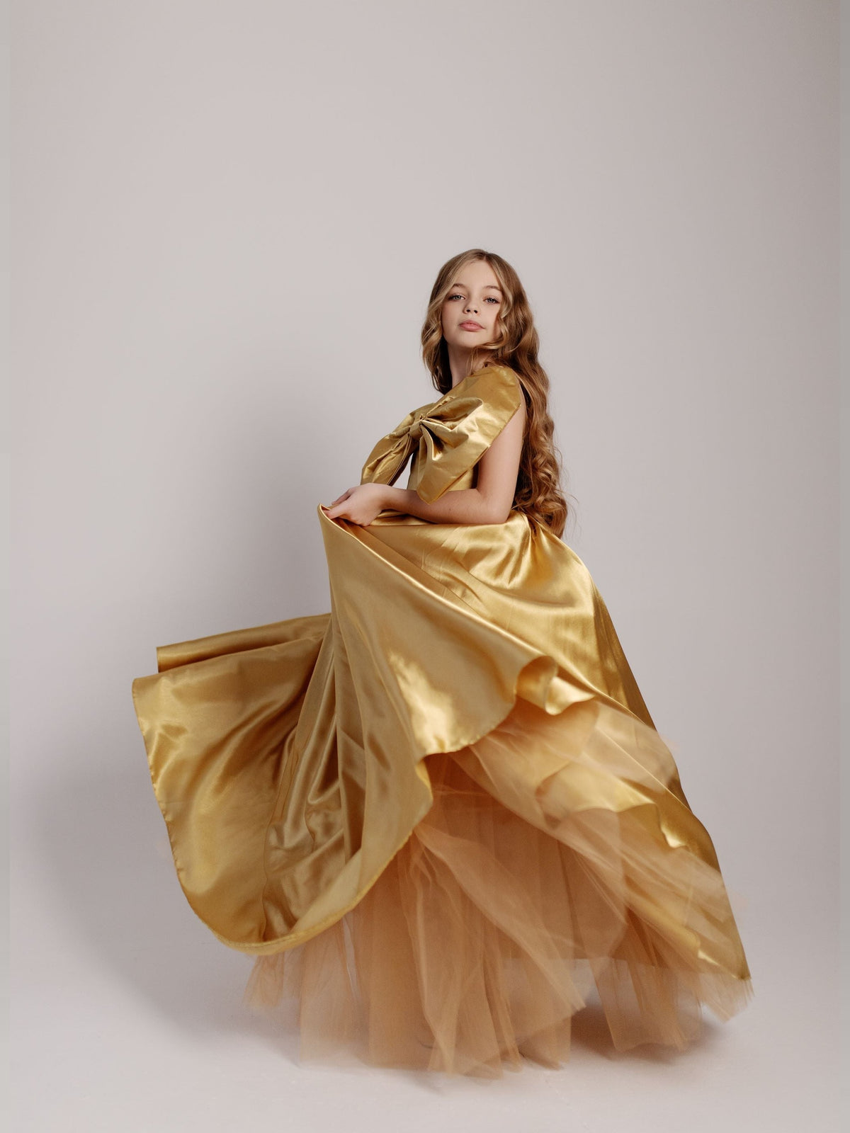 a woman in a gold dress posing for a picture