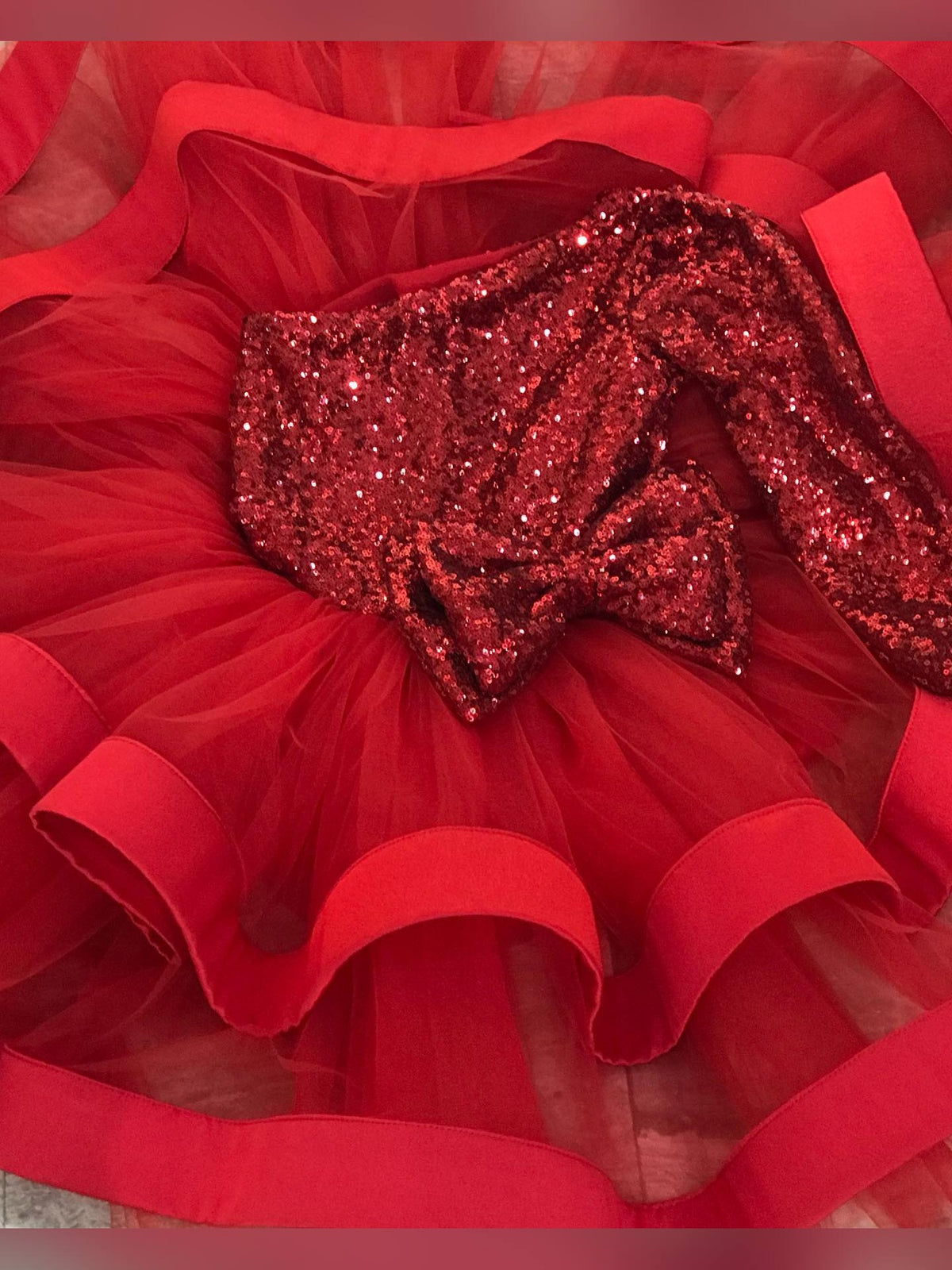 Christmas baby girl dress with fluffy puffy skirt and one long shoulder in red sequins, perfect for holiday events.
