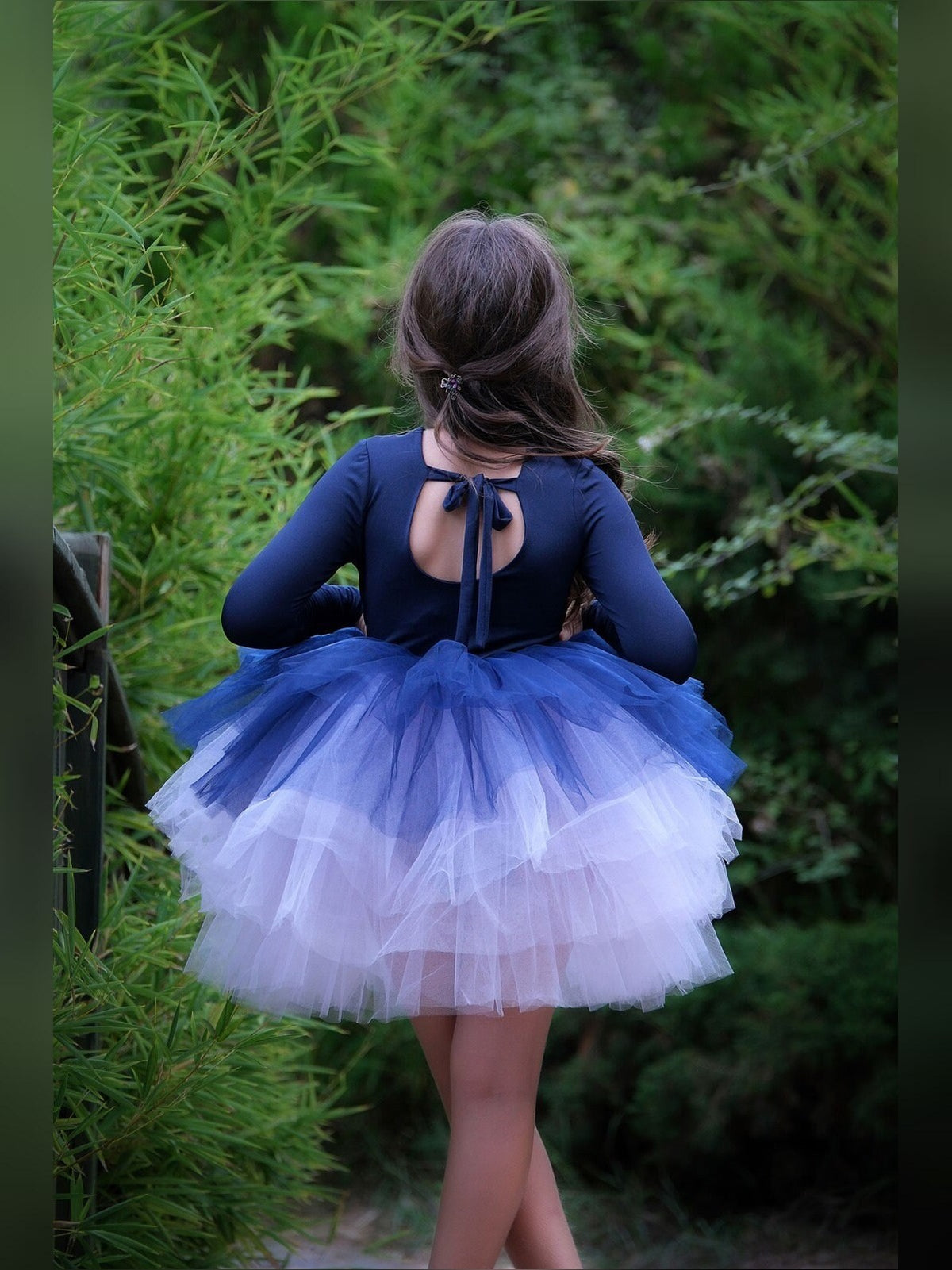 a little girl wearing a blue and white dress