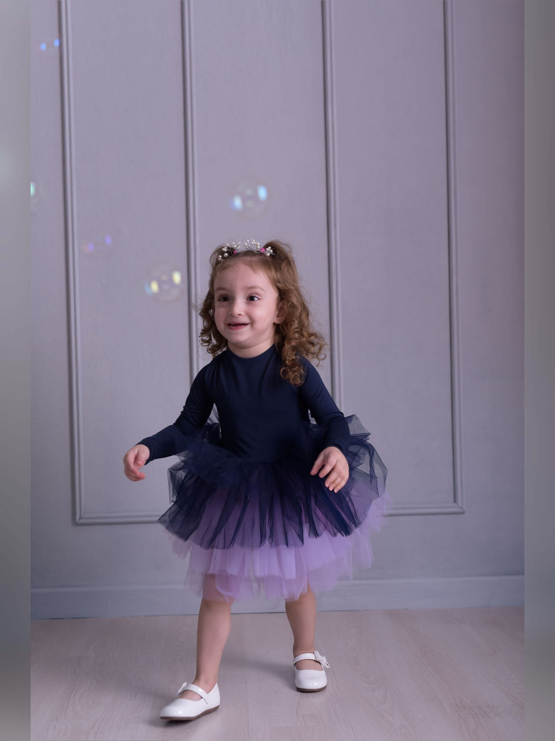 a little girl wearing a purple and blue dress