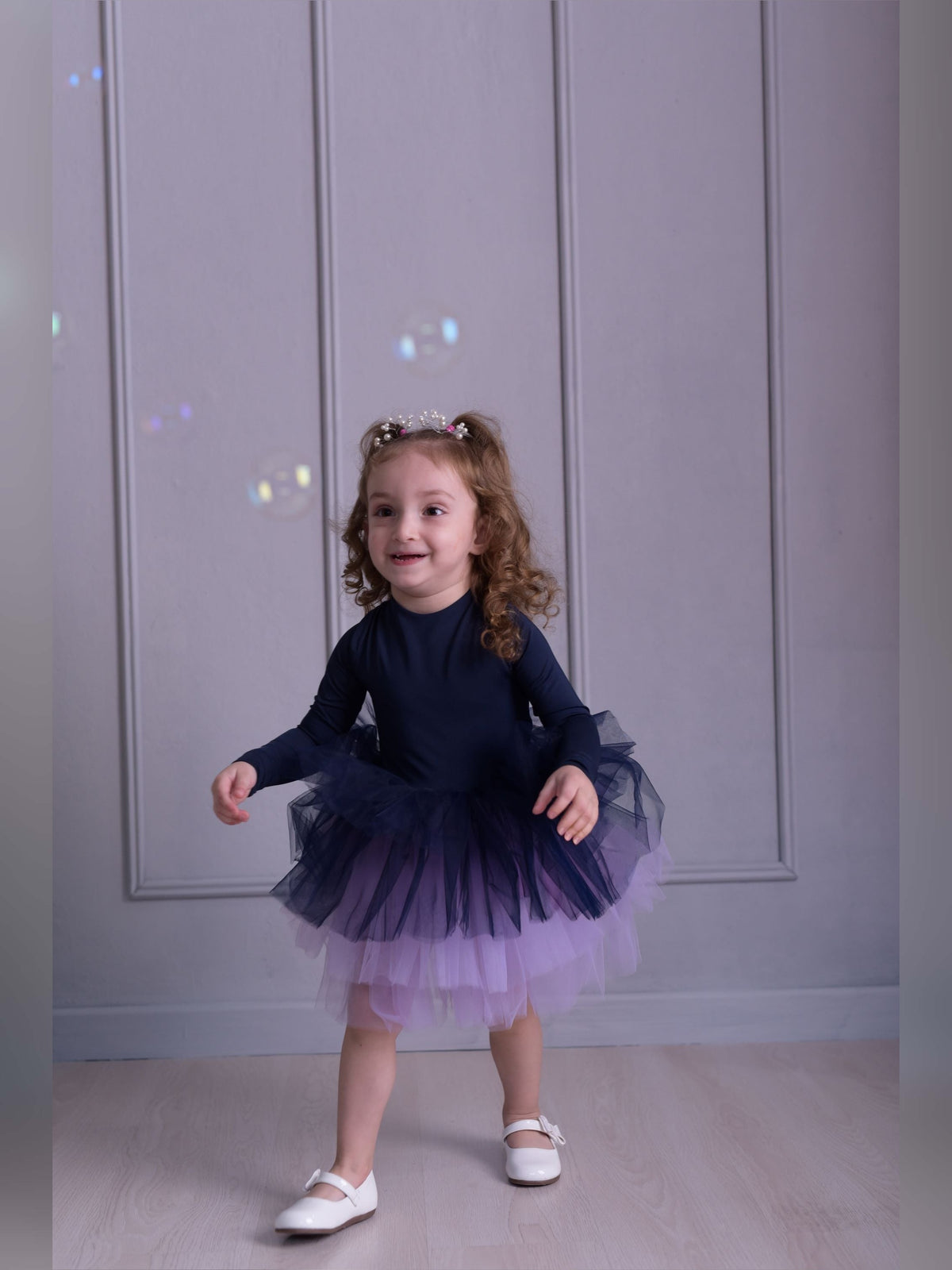 a little girl wearing a purple and blue dress