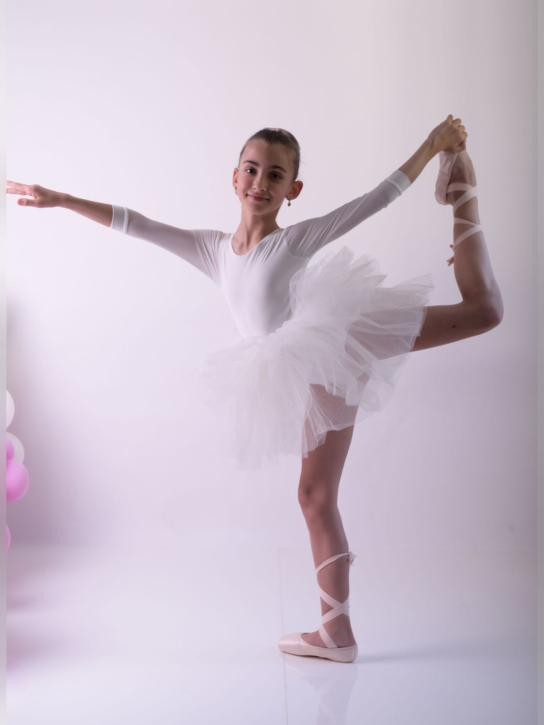 a young ballerina is posing for a picture