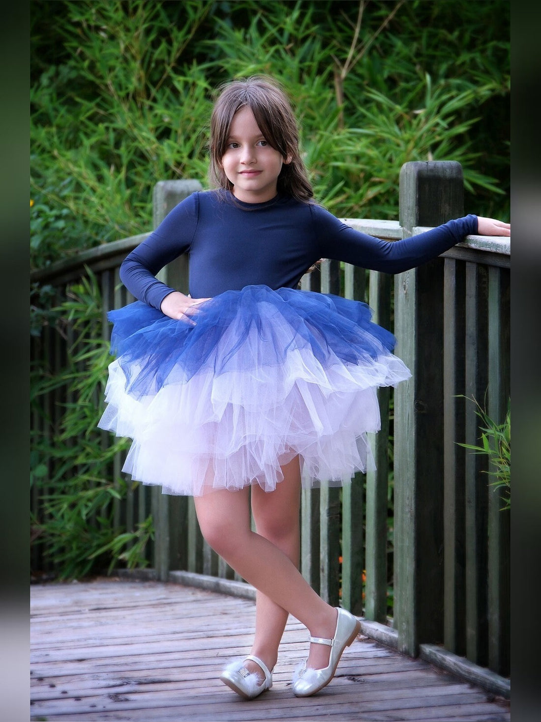 a little girl wearing a blue and white dress