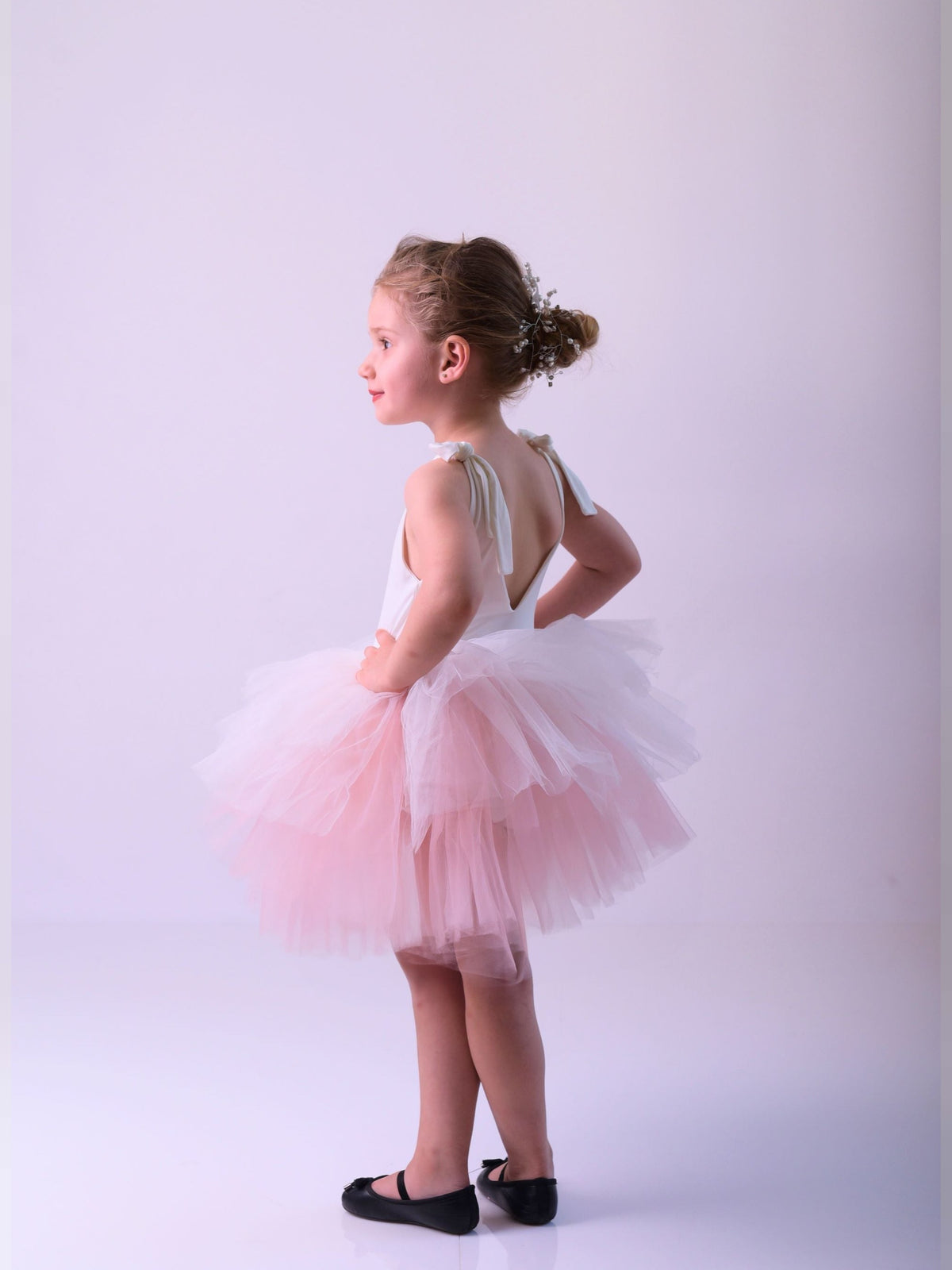 a little girl wearing a pink tutu skirt