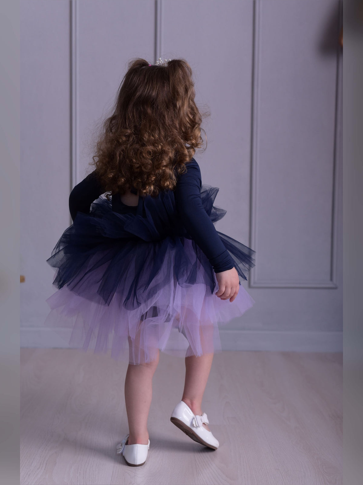 a little girl wearing a purple and blue dress