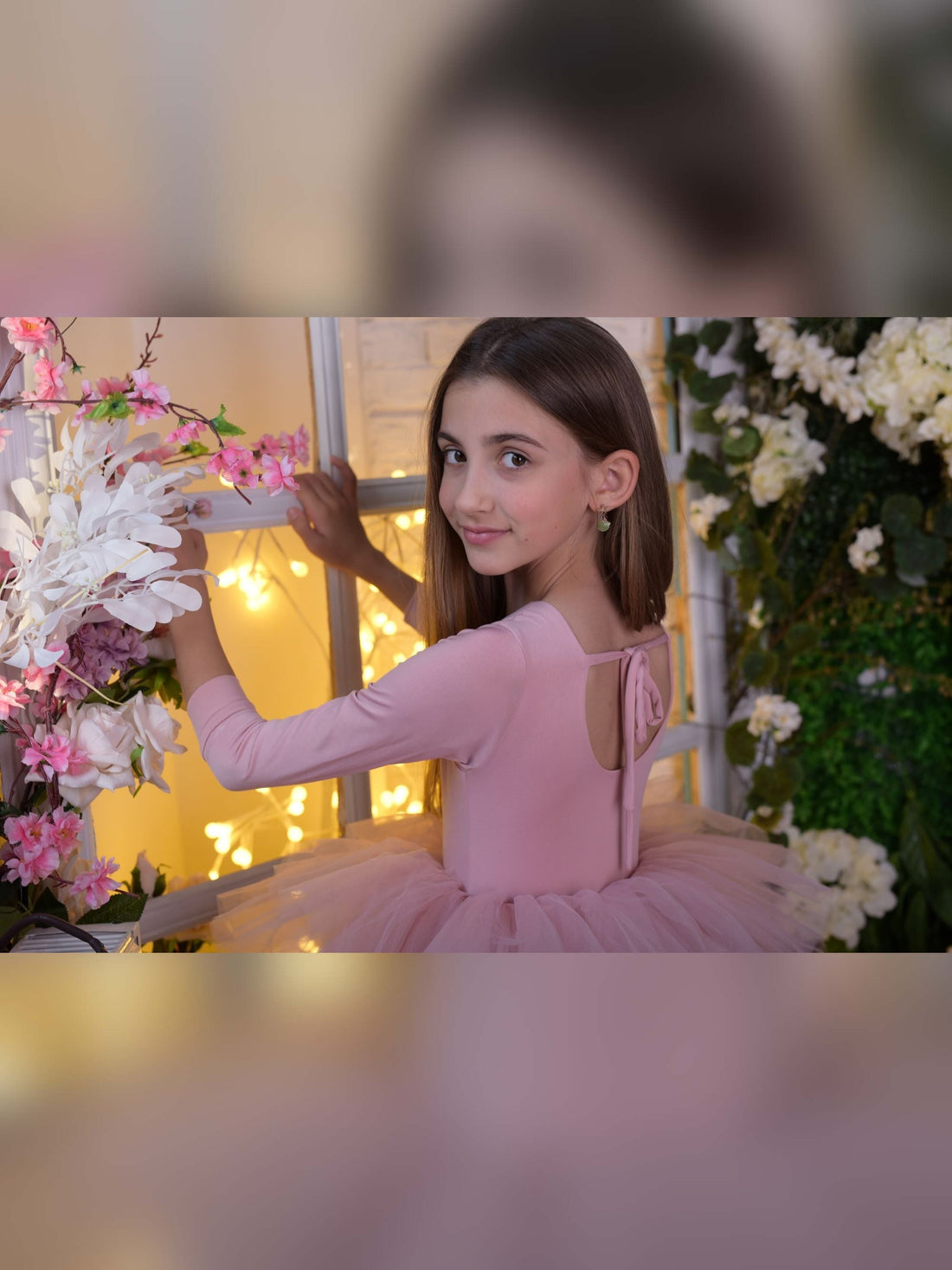 a little girl in a pink dress holding a bouquet of flowers
