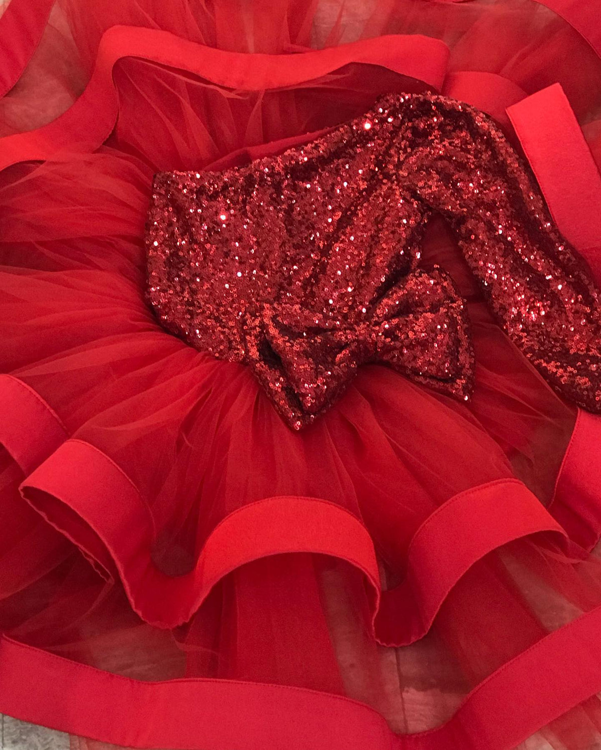 Christmas baby girl dress with fluffy puffy skirt and one long shoulder in red sequins, perfect for holiday events.
