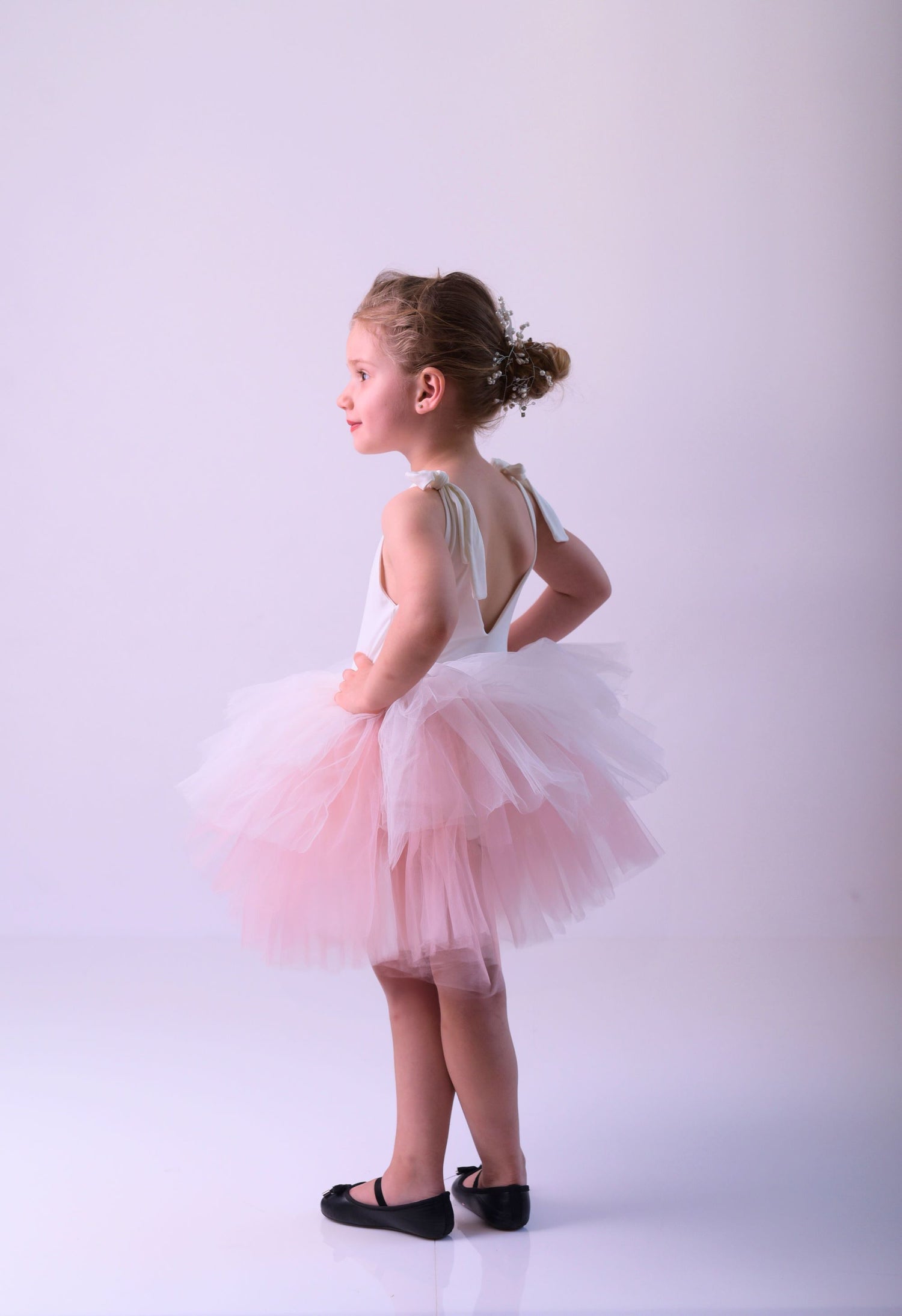 a little girl wearing a pink tutu skirt