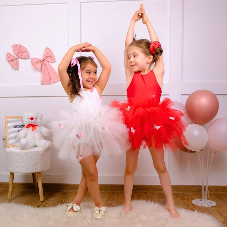 two young girls in red and white tutu skirts