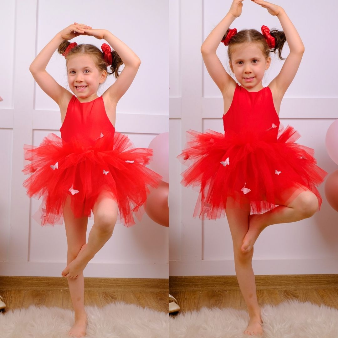 a little girl wearing a red tutu and a red dress