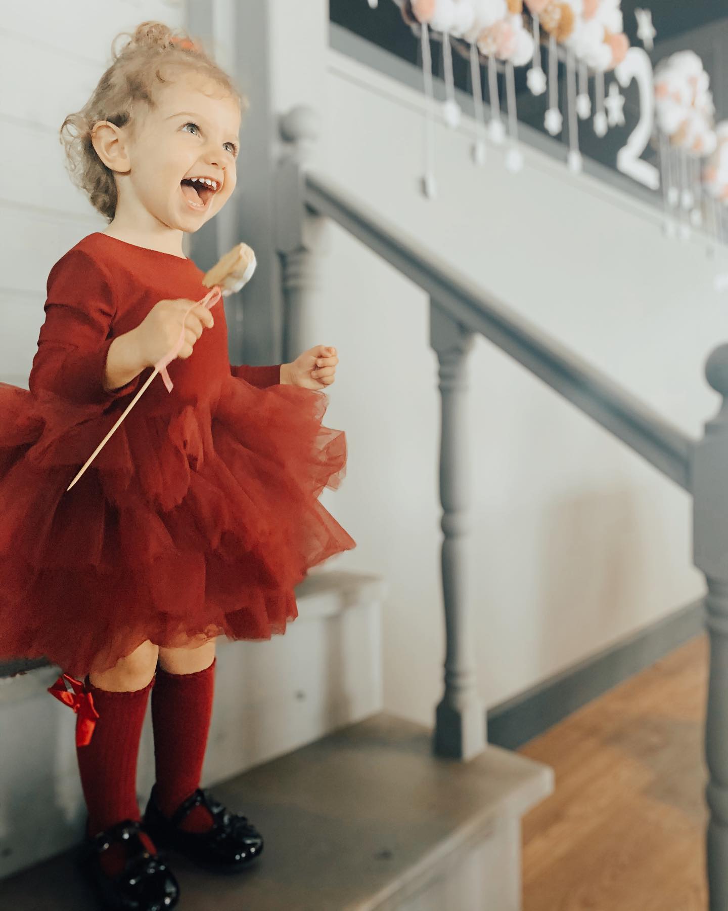 a little girl wearing a red dress and red socks