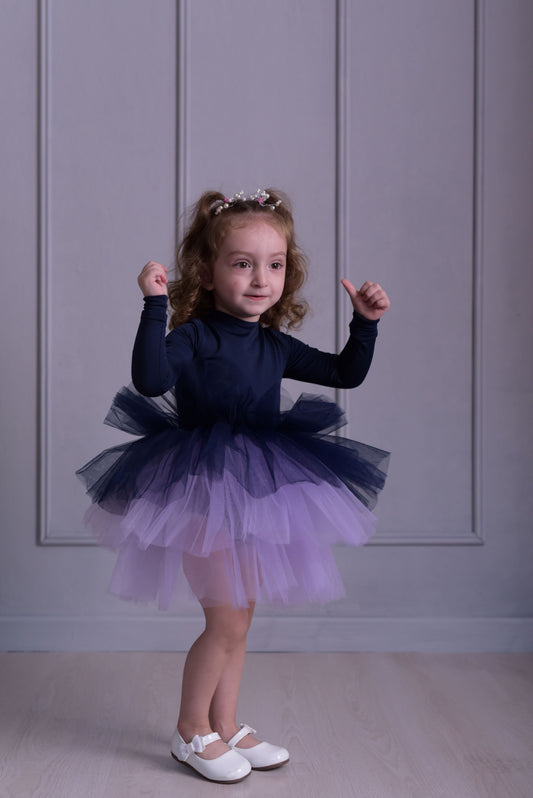 a little girl wearing a purple and blue dress