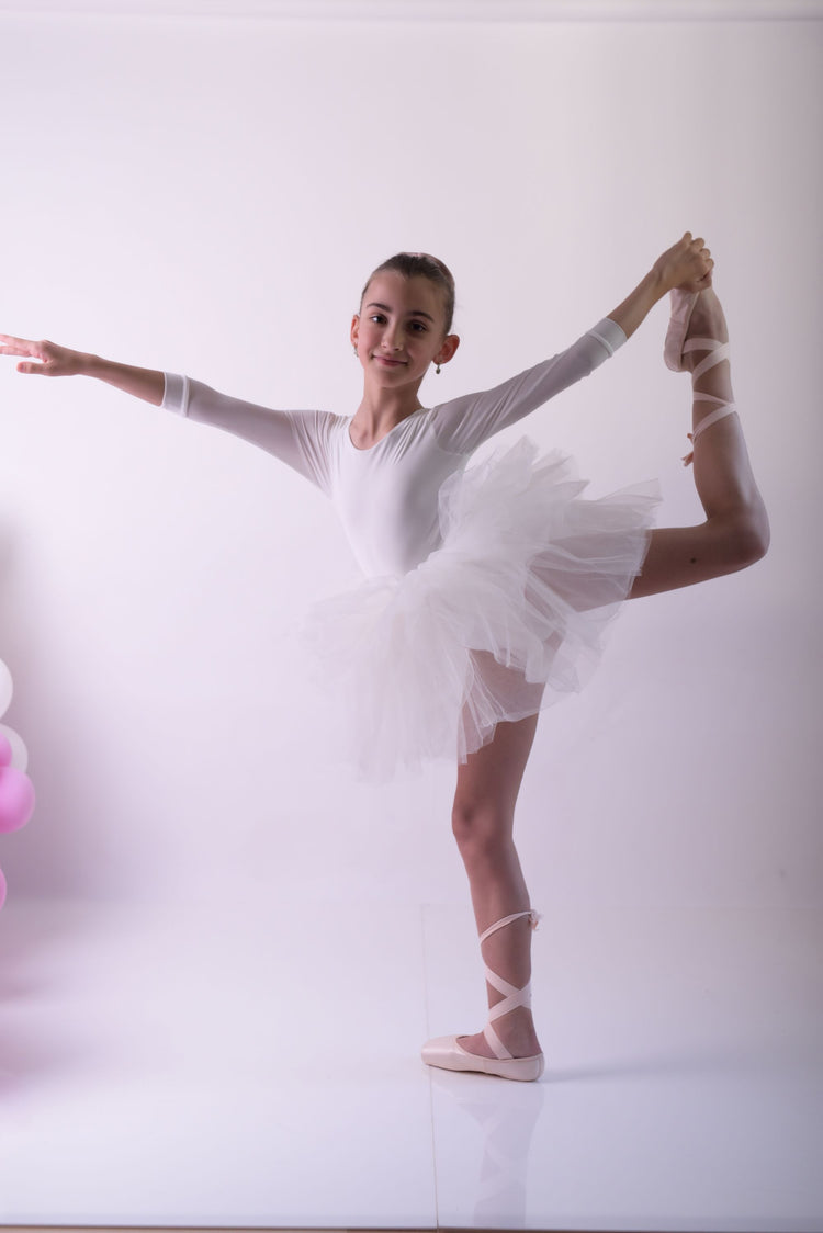 a young ballerina is posing for a picture