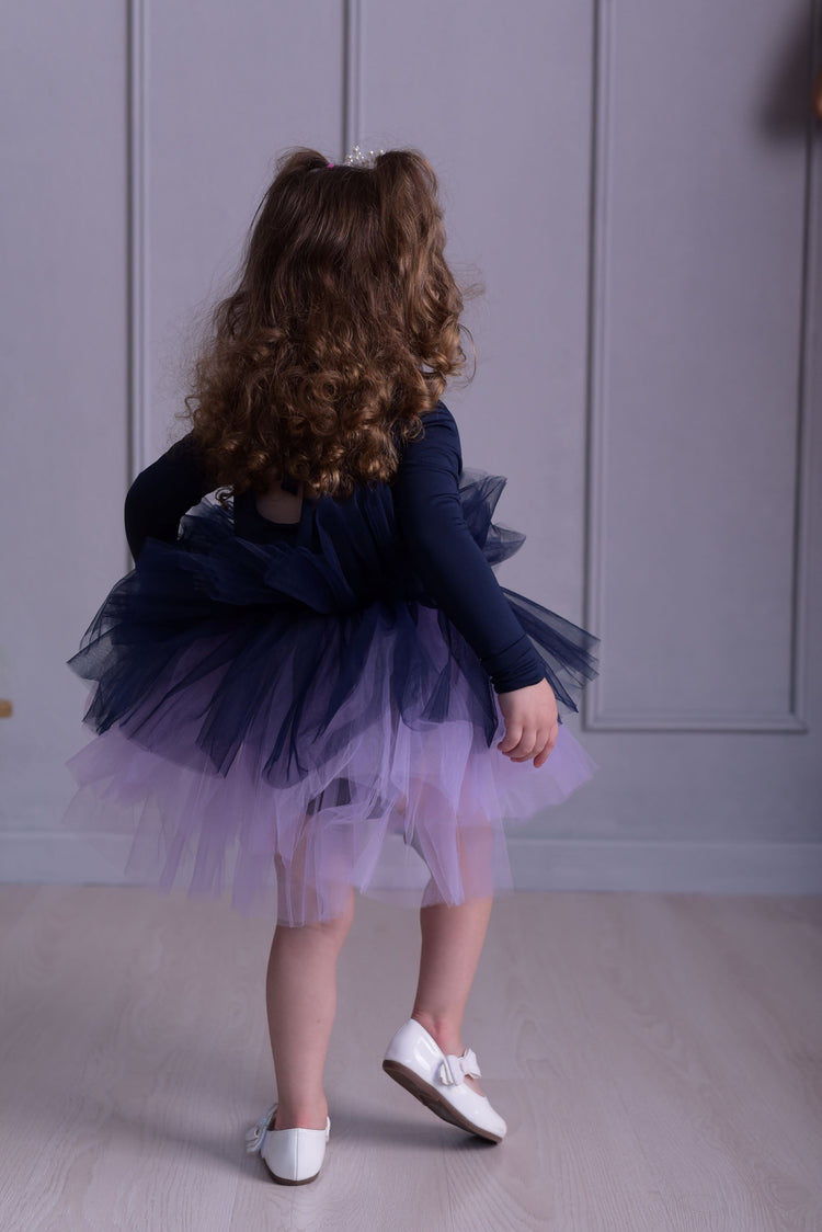 a little girl wearing a purple and blue dress