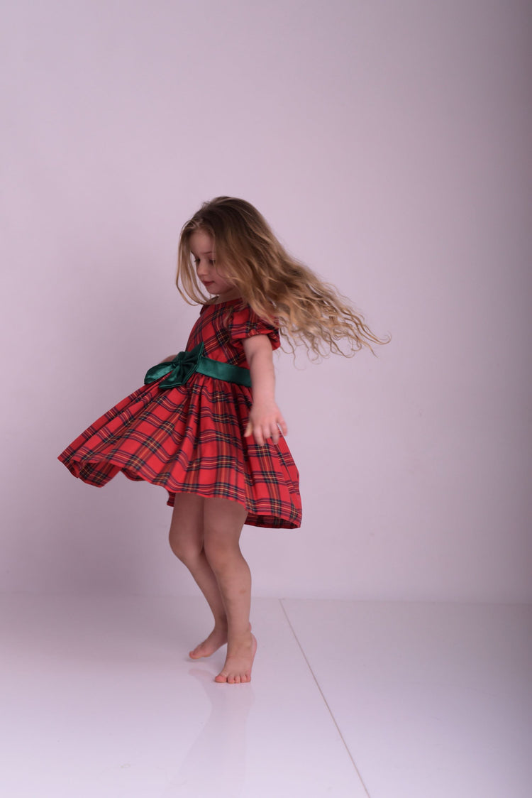 a little girl in a red and black dress