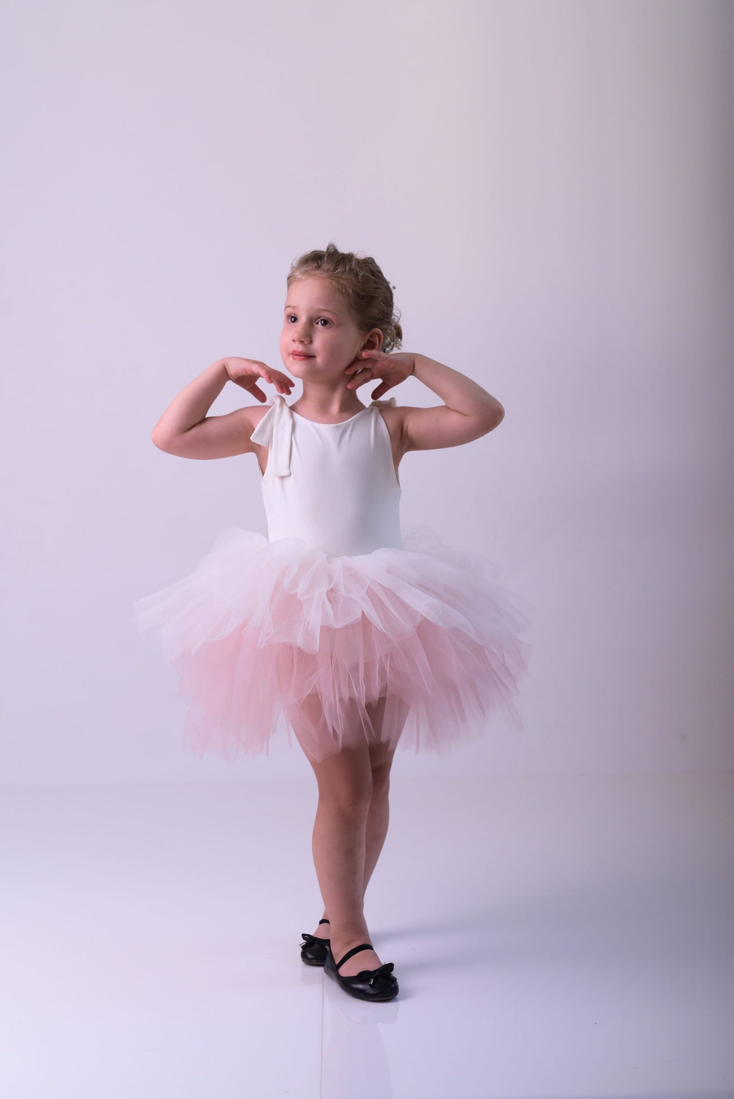 a little girl wearing a pink tutu and ballet shoes