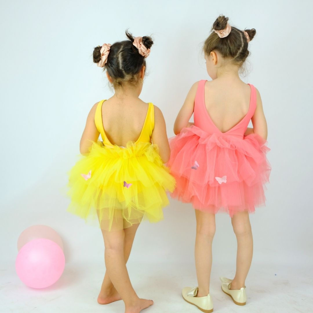 two little girls dressed in colorful tutus and ballet shoes