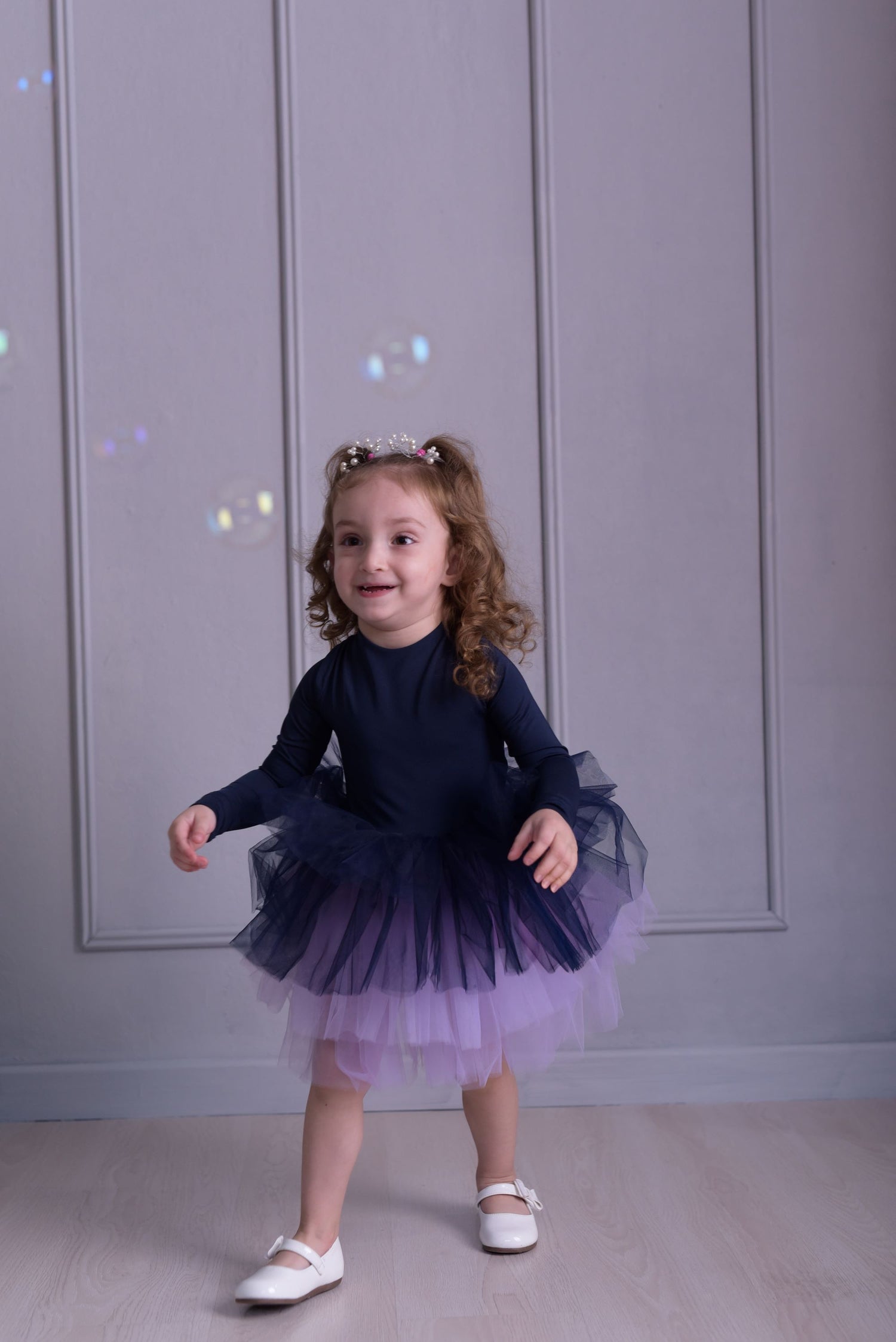 a little girl wearing a purple and blue dress